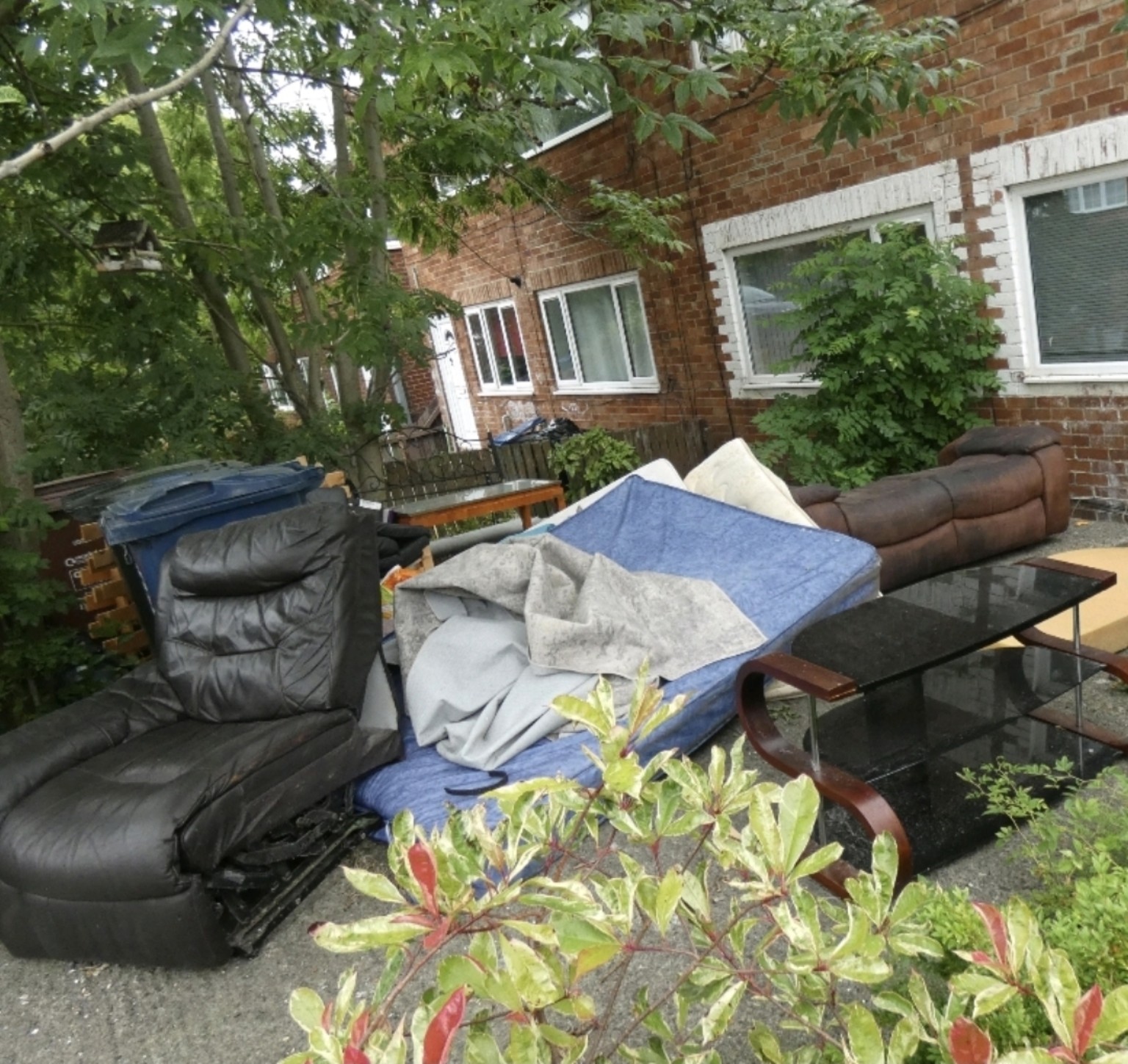 Used sofas, mattresses and bulky furniture ready for clearance outside a property
